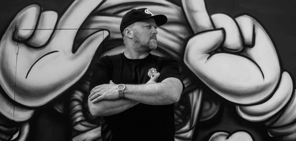 Portrait de Craig « Wotto » Watkins devant une fresque — Wotto